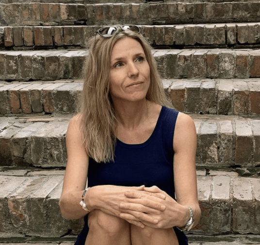 Jane Livoni, designeren bag PerleMust, der sidder på en trappe.